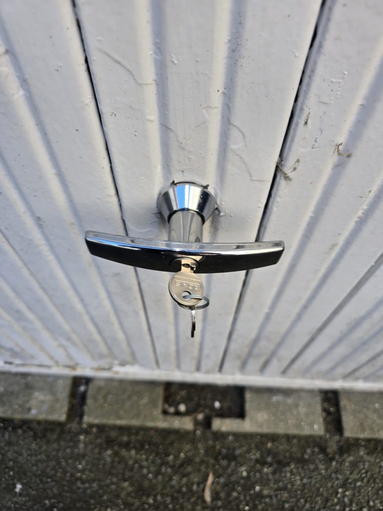 Poignée à condamnation Ronis installée sur porte de garage basculante